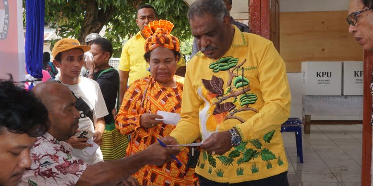 Mengenakan Busana Warna Cerah, Calon Wali Kota Abisai Rollo Gandeng Istri Salurkan Hak Suara