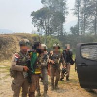 Satgas ODC bersama personel kepolisian mengenakan seragam taktikal sedang menggiring/mengamankan seorang pria di dekat kendaraan taktis (Foto : Istimewa)